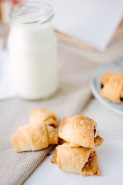 Kumaş malzeme şişe süt ile üzerinde croussants ev yapımı.