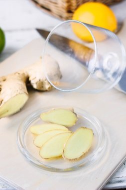 Ahşap tahta üzerinde cam tabakta zencefil kökü dilim.