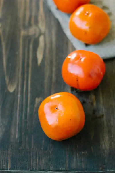 Linia persimmons na drewnianym stole — Zdjęcie stockowe