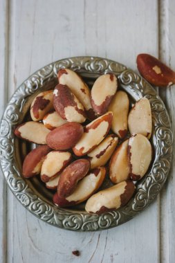 Brezilya fıstığı Beyaz ahşap masa üzerinde metal plaka.