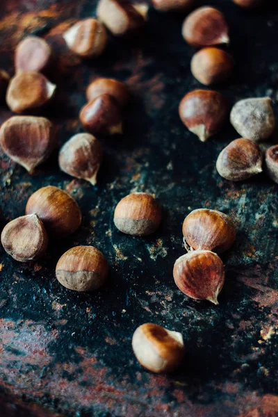 Lote de castanhas sobre a superfície rústica preta — Fotografia de Stock