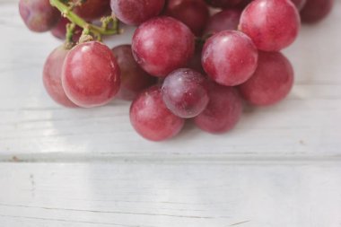 Kırmızı üzüm Beyaz ahşap tahta üzerinde.