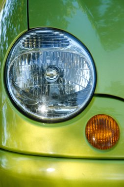 Arabanın bir parçası: yeşil arabanın farları ve dönüş sinyali.