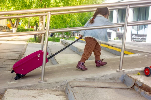 Little girl travel alone. Now she on the railway station.