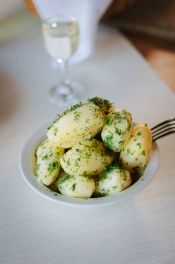 Genç patatesler, restoran masasındaki otlarla kaynıyor..