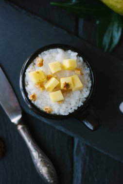 Siyah arkaplanda mango ve pirinç tatlısı manzarası.