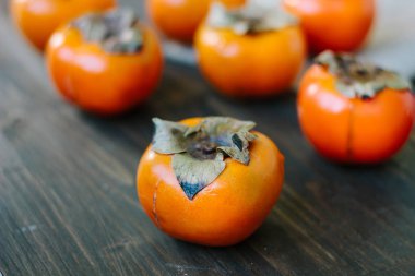 Taze portakal hurmaları ahşap masada..