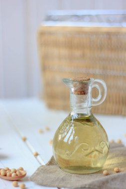 Etrafında soya fasulyesi olan cam şişedeki soya fasulyesi yağı..