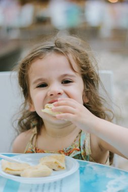 Fast food kafede yemek yiyen küçük bir kız..