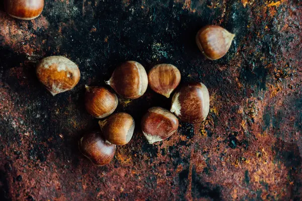 Lote de castanhas sobre a superfície rústica preta — Fotografia de Stock