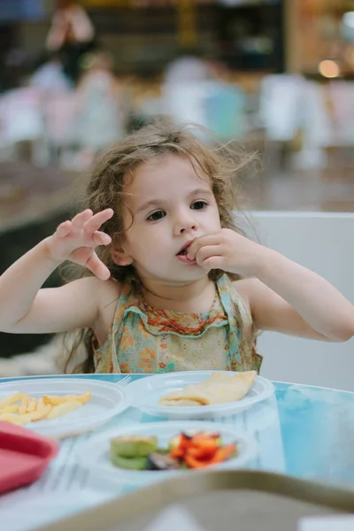 Niña divirtiéndose con la comida en el café o restaurante. — Foto de Stock