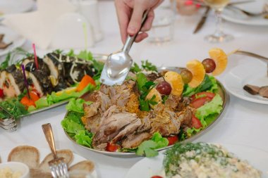 Elleri maşalı Noel hindisini yemek için ayırır..