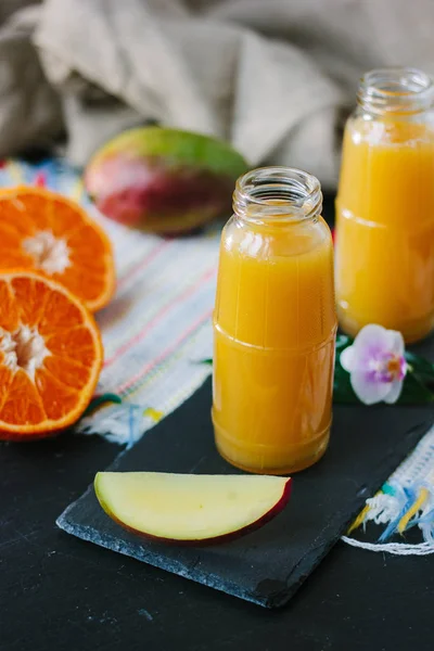 Batido de mango y naranja en botella transparente. —  Fotos de Stock