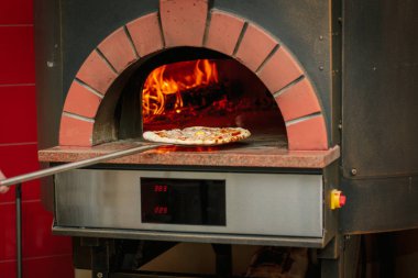 Pizza üzerinde geleneksel pizza fırın küreği.