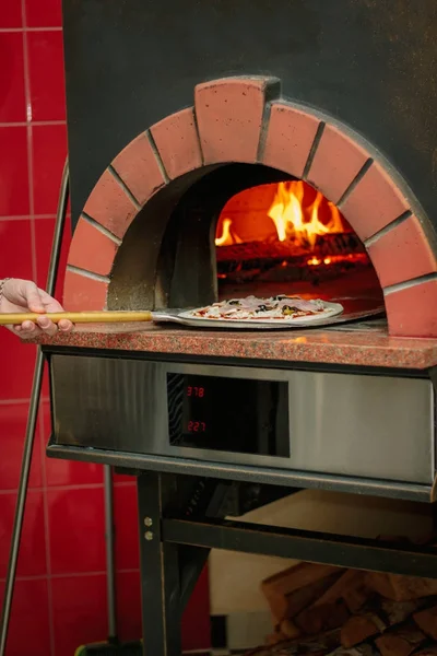 Pizza auf Schaufel im traditionellen Pizzaofen. — Stockfoto