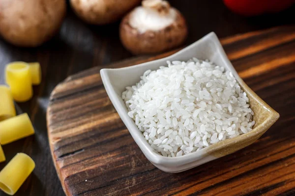 Cuenco de cerámica con el arroz sobre tabla de madera . — Foto de Stock