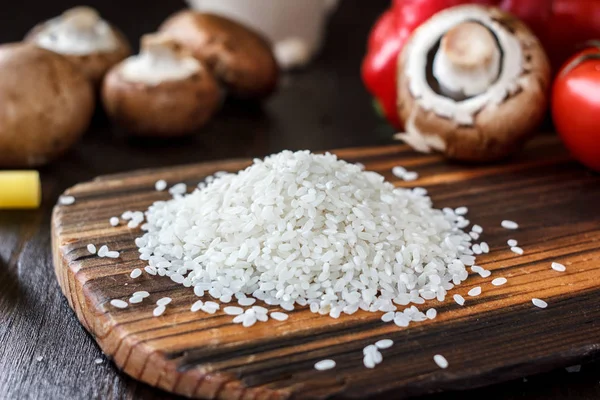 Ramo de arroz en una tabla de cocina de madera . — Foto de Stock