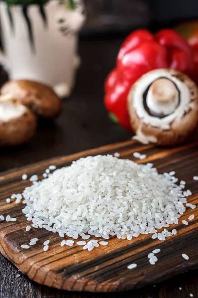 Ramo de arroz en una tabla de cocina de madera . — Foto de Stock