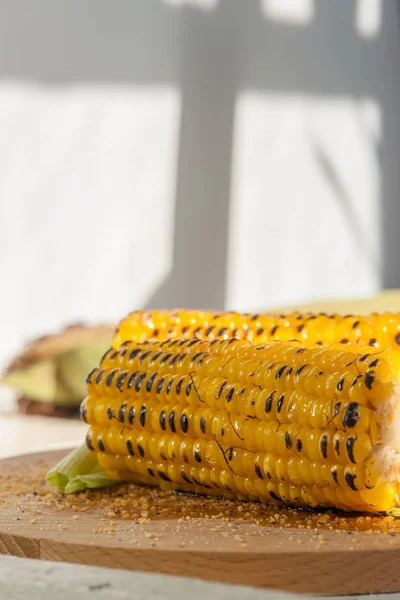 Two grilled corn on a wooden plate — Stock Photo, Image