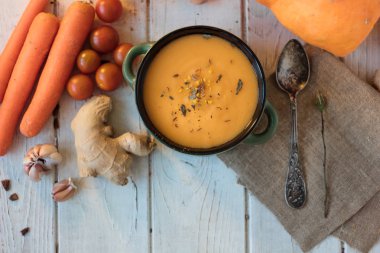 Beyaz yüzeyde zencefilli havuç kremalı çorba manzarası.