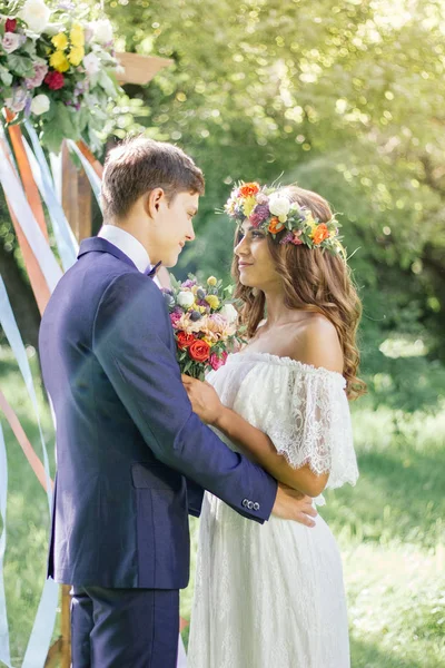 Wedding ceremony at outdoor park - bride and groom touching each other. — Stock Photo, Image