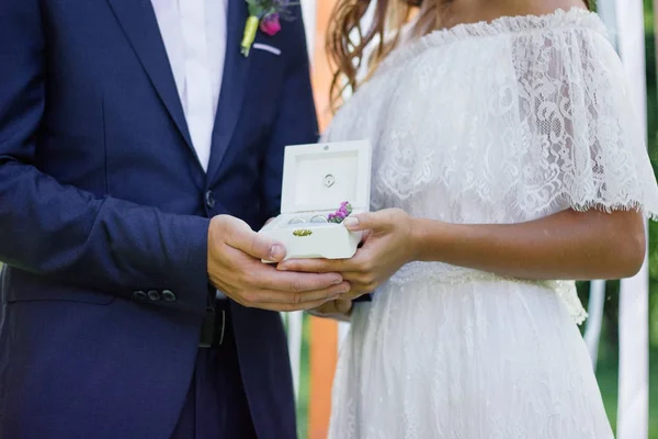 Box with wedding rings in groom and bride hands. — Stock Photo, Image