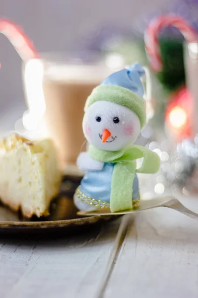 Christmas snowman sitting near the piece of pie. — Stock Photo, Image