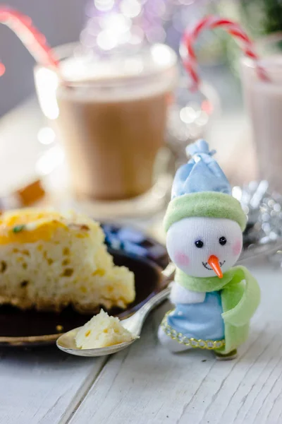 Christmas decoration at white table - snowman with piece of pie in spoon. — Stock Photo, Image