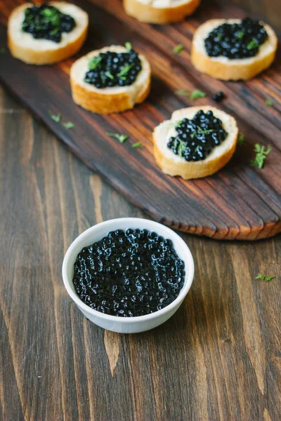 Caviar preto fresco em uma tigela de cerâmica branca . — Fotografia de Stock