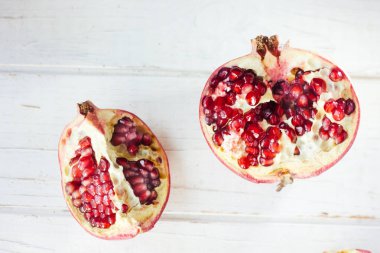 Beyaz ahşap yüzeyde taze nar parçaları..