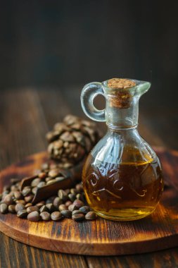 Ahşap masa üzerinde cam şişede sedir veya çam yağı.