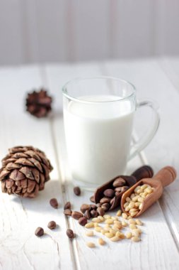 Beyaz ahşap masada çam fıstıklı sedir sütü..