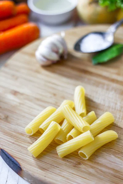 Rigatoni pasta över trä köksbordet — Stockfoto