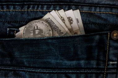 Rus ruble ve bitcoin sikke bir mavi kot pantolon cebinde.