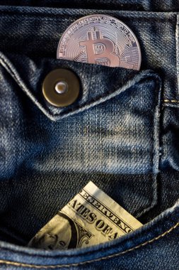Bitcoin 'li mavi kot pantolon ve cebinde dolar.