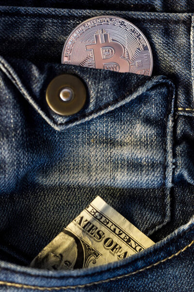 Blue jeans with bitcoin coin and bucks in a pocket.