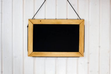 Duvardaki yazı tahtası. Beyaz ahşap duvar siyah kurulu ile.