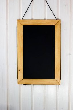 Duvardaki yazı tahtası. Beyaz ahşap duvar siyah kurulu ile.