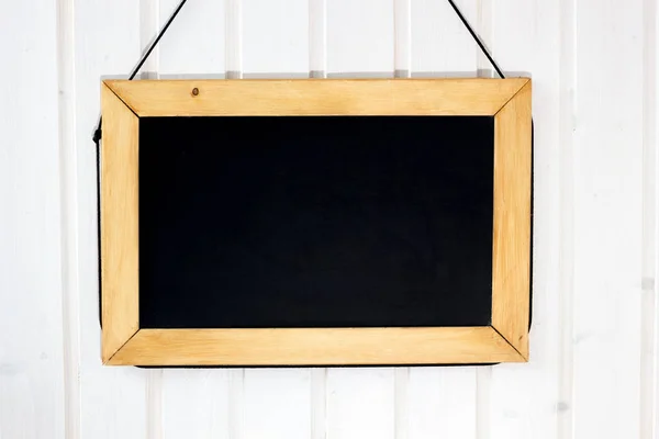 Blackboard on the wall. White wooden wall with black board on it. — Stock Photo, Image