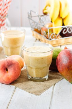 Mango ve şeftali smoothie malzemeler ahşap tablo.