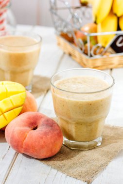 Mango ve şeftali smoothie malzemeler ahşap tablo.