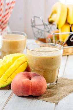 Mango ve şeftali smoothie malzemeler ahşap tablo.