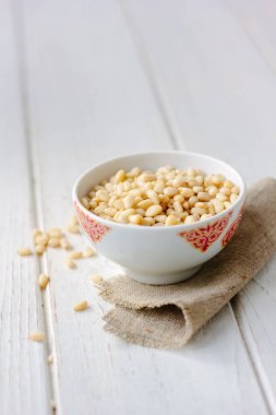 Çam fıstığı ahşap masa üzerinde bir seramik kase.