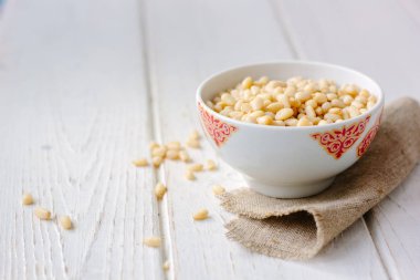 Çam fıstığı ahşap masa üzerinde bir seramik kase.