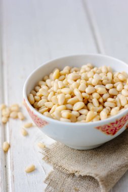 Çam fıstığı ahşap masa üzerinde bir seramik kase.