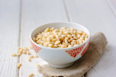 Çam fıstığı ahşap masa üzerinde bir seramik kase.