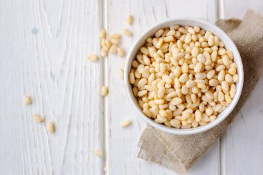 Çam fıstığı ahşap masa üzerinde bir seramik kase.