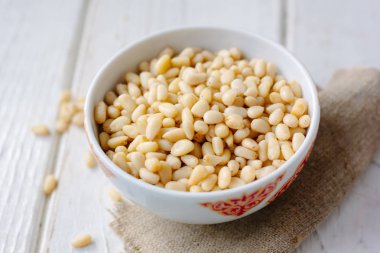 Çam fıstığı ahşap masa üzerinde bir seramik kase.