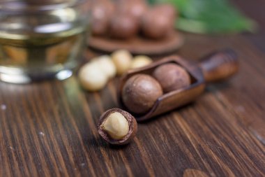 Karanlık tablo üzerinde tahta bir kaşık içinde Macadamia fındık.