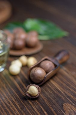 Karanlık tablo üzerinde tahta bir kaşık içinde Macadamia fındık.